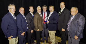 The SMP team is presented the Outstanding Vendor of the Year Award by Bo Fisher, chairman of Federated Auto Parts and Rusty Bishop, CEO of Federated Auto Parts.  (L to R): Leon Delong, Brad Rapp, Fisher, Ken Wendling, Larry Sills, Bishop, Bill Collins and John Gethin.