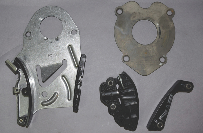 The original thrust plate that included the chain guide and tensioner was replaced by a separate thrust plate, a chain guide and a plastic tensioner with a spring-loaded piston.